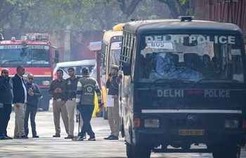 Police officials conducting security checks at a Delhi school after bomb threat email, students evacuated safely
